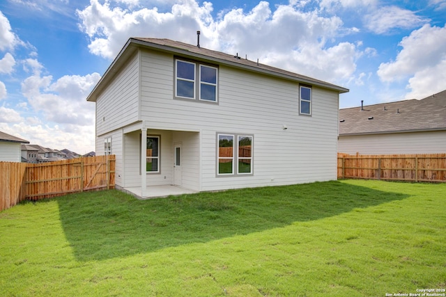 back of house with a patio area, a lawn, and a fenced backyard