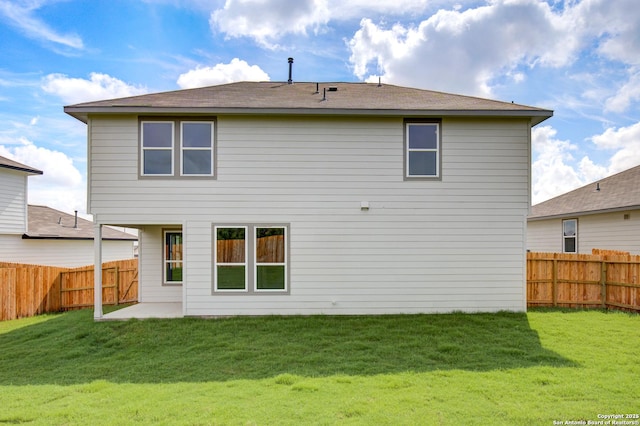 rear view of house featuring a fenced backyard and a yard