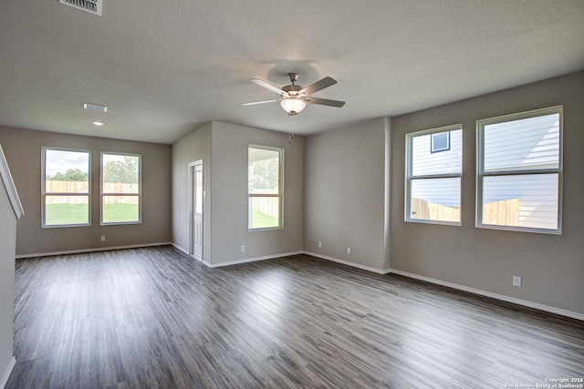 unfurnished room featuring ceiling fan, baseboards, a textured ceiling, and dark wood-style floors