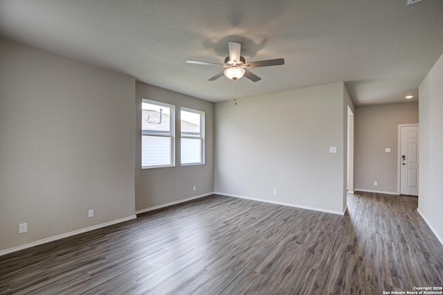 empty room featuring dark wood-style floors, a textured ceiling, a ceiling fan, and baseboards