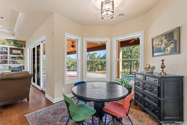 dining space with baseboards, visible vents, and wood-type flooring