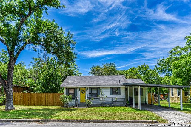 ranch-style house with an attached carport, fence, a front lawn, and driveway