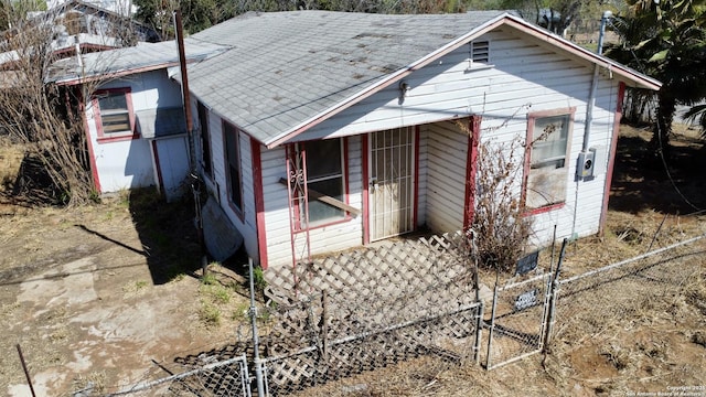 exterior space with roof with shingles and fence