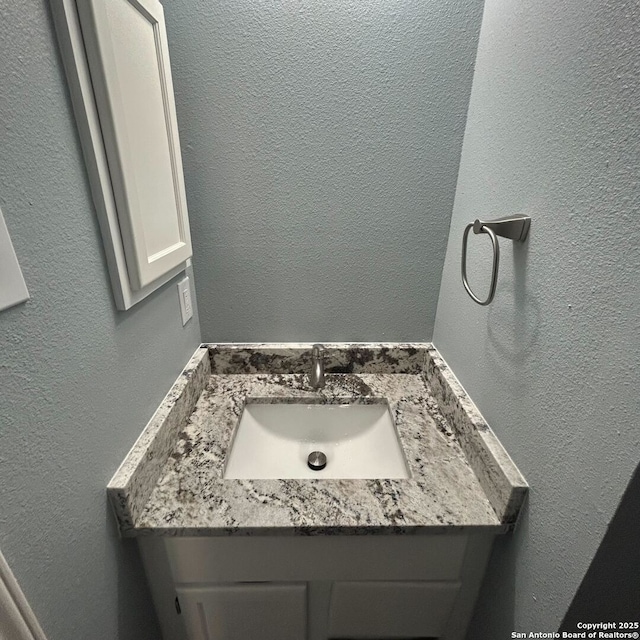 bathroom with vanity and a textured wall