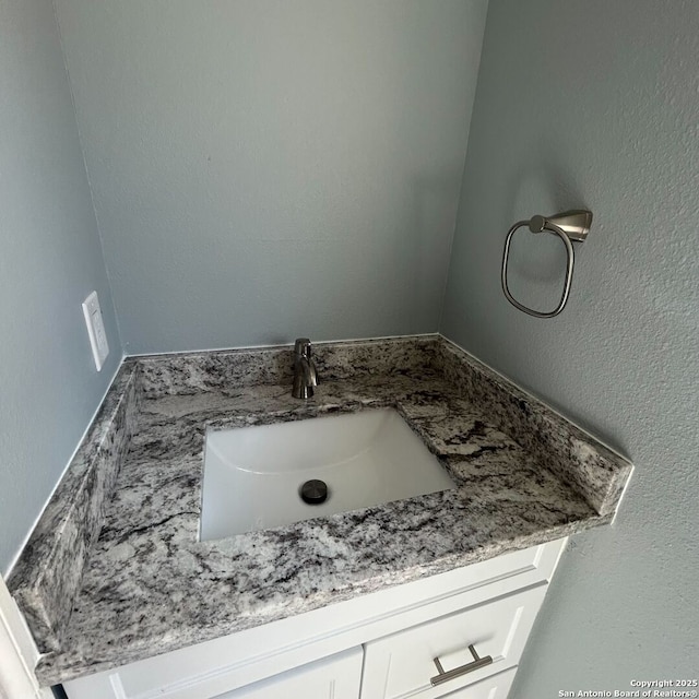 bathroom featuring vanity and a textured wall