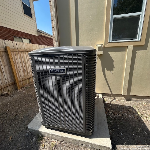 details with central air condition unit, fence, and stucco siding