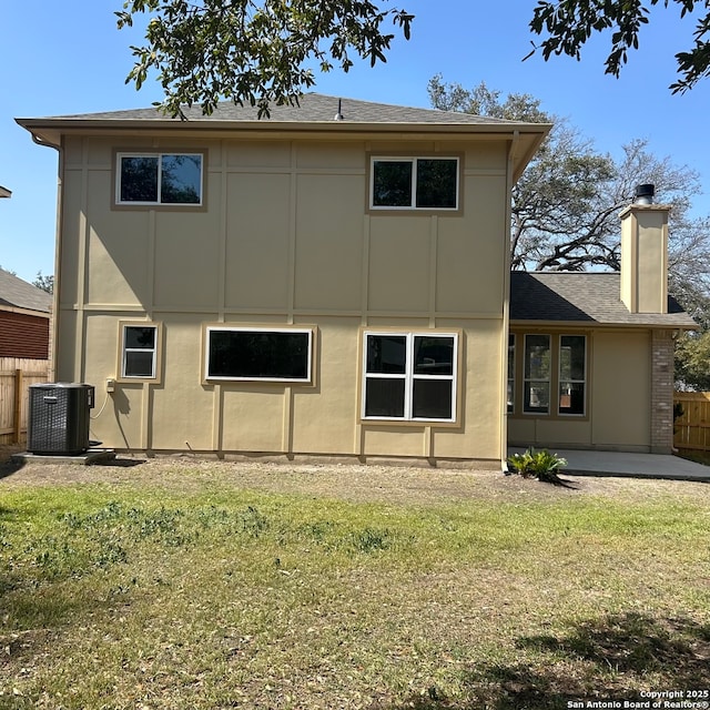 back of property featuring fence, central air condition unit, a lawn, a chimney, and a patio