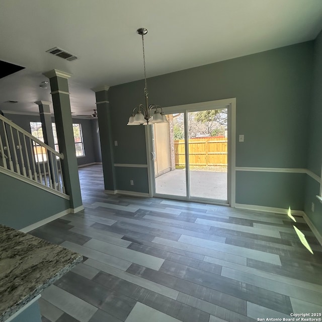 unfurnished dining area featuring an inviting chandelier, stairway, plenty of natural light, and visible vents