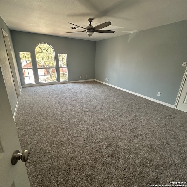 unfurnished room featuring a ceiling fan, visible vents, carpet, and baseboards