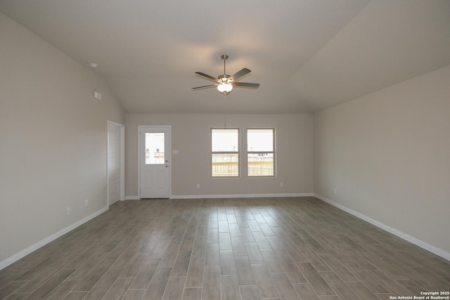 unfurnished living room with lofted ceiling, wood finished floors, baseboards, and ceiling fan