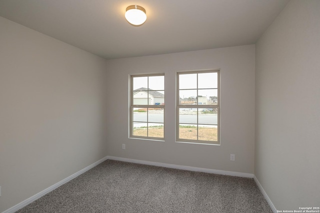 empty room featuring baseboards and carpet floors