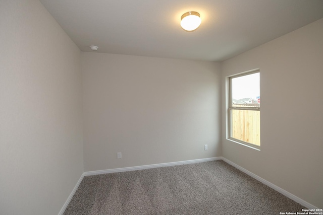 unfurnished room with light colored carpet and baseboards