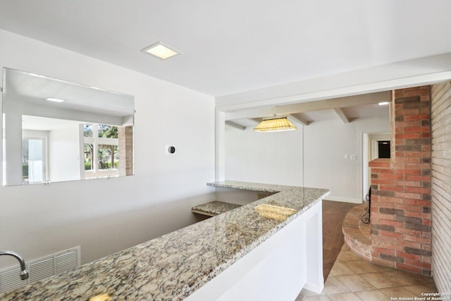 interior space with light stone counters and light tile patterned floors