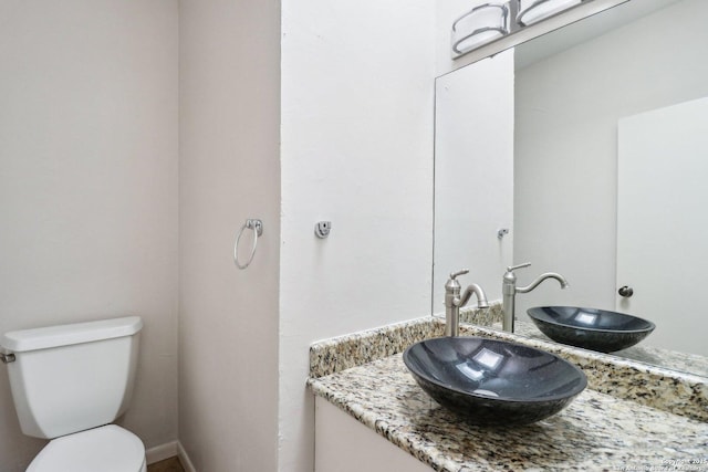 half bathroom featuring toilet and vanity