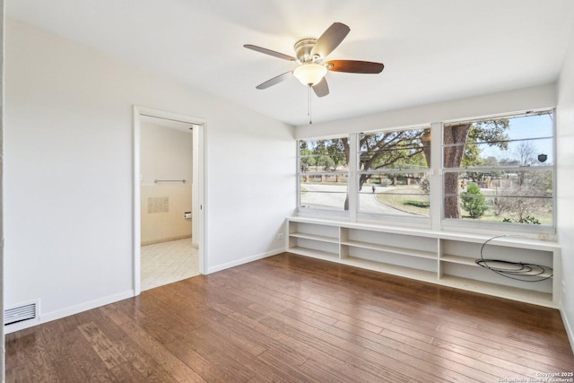 spare room with visible vents, ceiling fan, baseboards, and wood-type flooring