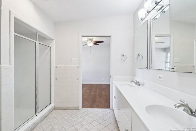 full bathroom with a sink, tile walls, a shower stall, and tile patterned flooring