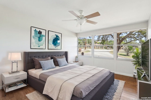 bedroom featuring a ceiling fan, wood finished floors, and baseboards