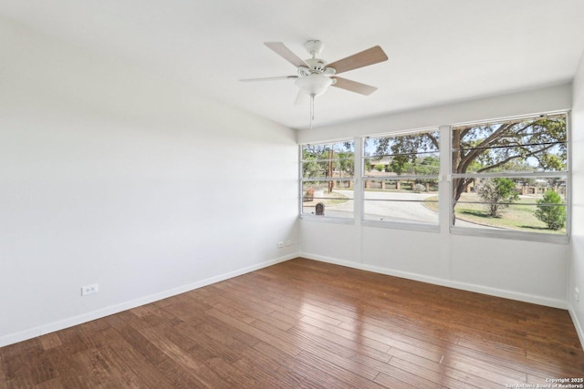 spare room with a ceiling fan, wood finished floors, and baseboards