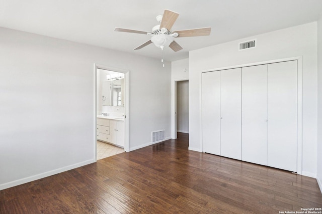 unfurnished bedroom with visible vents, baseboards, a closet, and wood finished floors