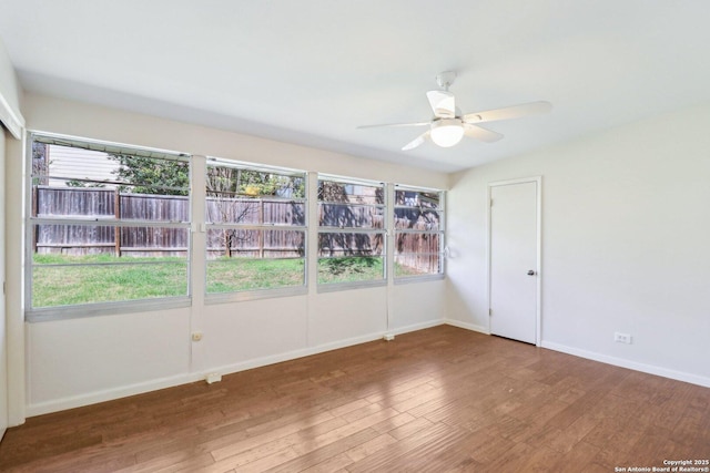 spare room featuring baseboards, a ceiling fan, and wood finished floors