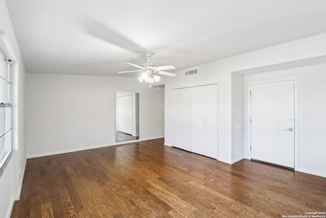 unfurnished bedroom featuring visible vents, ceiling fan, baseboards, wood finished floors, and a closet