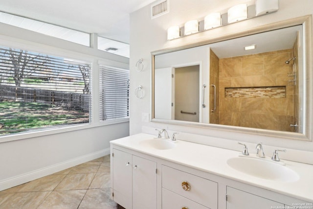 bathroom featuring a sink, visible vents, tile patterned floors, and a tile shower