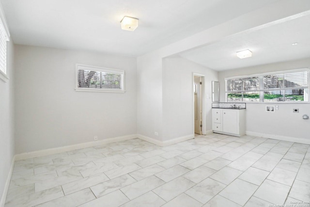 empty room featuring plenty of natural light and baseboards