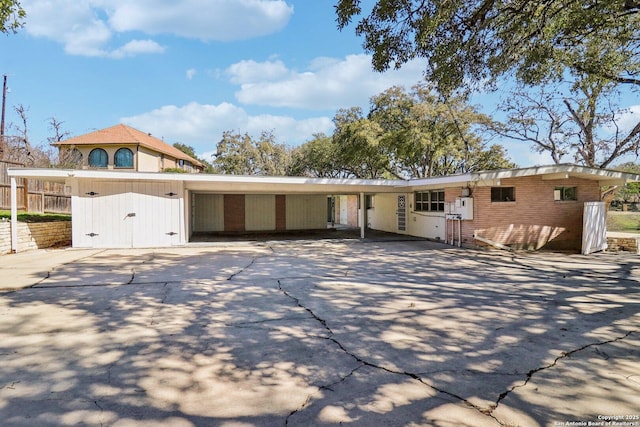 view of front facade featuring driveway, an attached carport, and brick siding