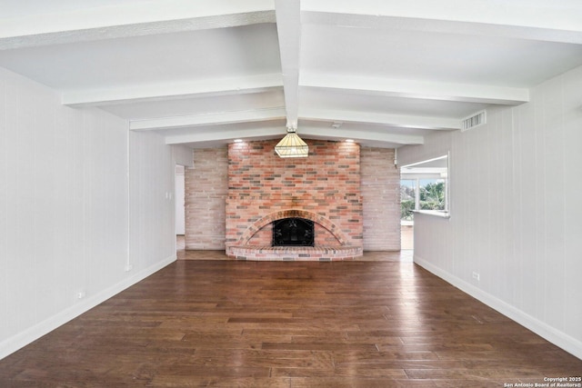 unfurnished living room with wood finished floors, baseboards, visible vents, beam ceiling, and a fireplace