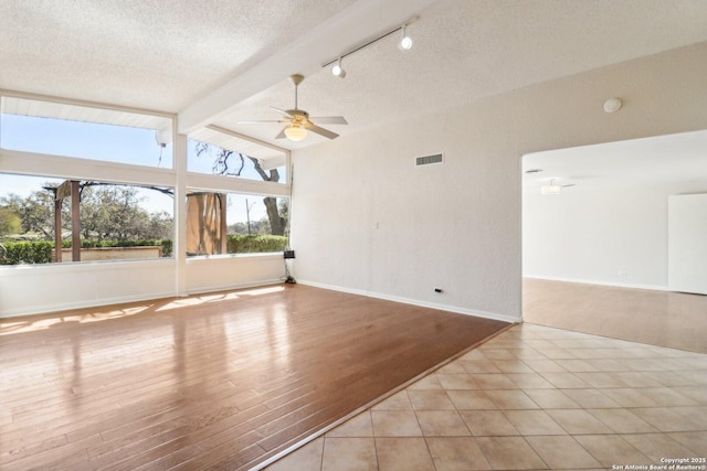 unfurnished room with wood finished floors, visible vents, vaulted ceiling with beams, ceiling fan, and a textured ceiling