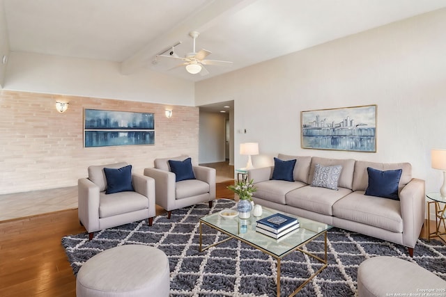 living room featuring ceiling fan, wood finished floors, and vaulted ceiling with beams