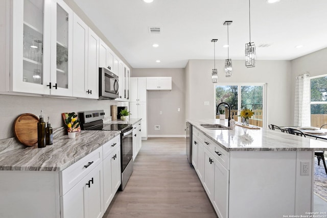 650 Canyon Cir, Canyon Lake, TX 78133 - kitchen featuring appliances with stainless steel finishes, a sink, light wood-style floors, white cabinets, and recessed lighting