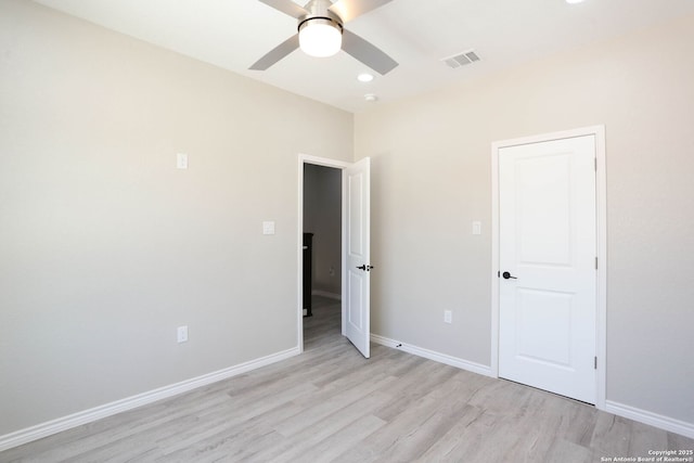 unfurnished bedroom featuring light wood-style floors, baseboards, a ceiling fan, and visible vents