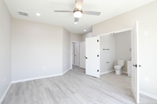 unfurnished bedroom with light wood finished floors, visible vents, baseboards, and connected bathroom