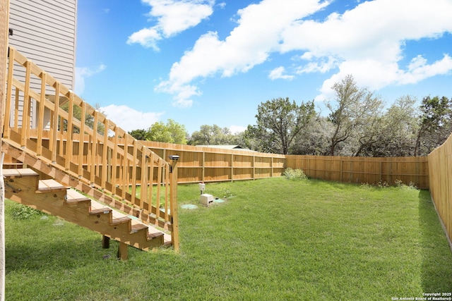 view of yard with stairway and a fenced backyard