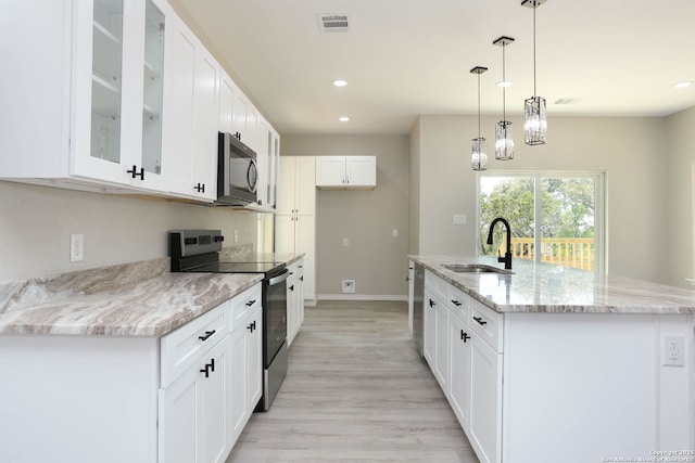 kitchen with recessed lighting, glass insert cabinets, visible vents, appliances with stainless steel finishes, and a sink