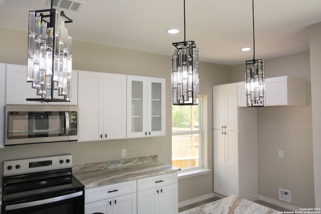 kitchen featuring a chandelier, white cabinets, and appliances with stainless steel finishes