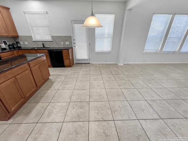 kitchen featuring brown cabinets, black dishwasher, dark countertops, tasteful backsplash, and light tile patterned floors