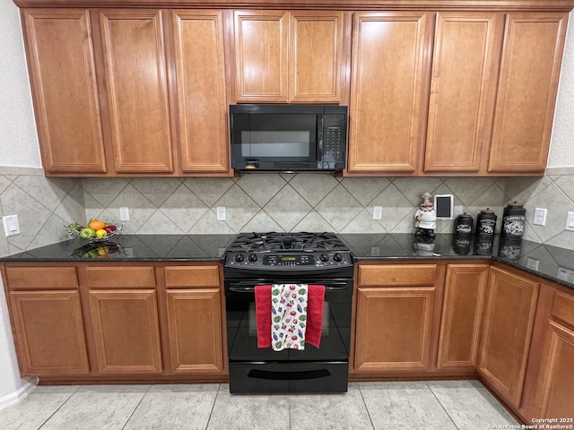 kitchen with dark stone countertops, light tile patterned floors, brown cabinets, black appliances, and tasteful backsplash