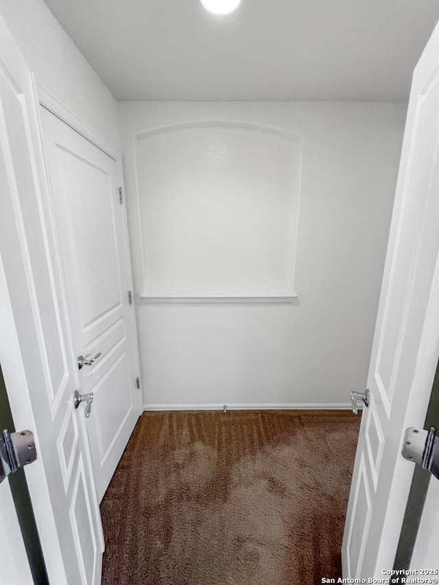 carpeted empty room featuring baseboards