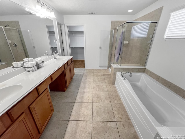 bathroom with tile patterned flooring, visible vents, a stall shower, and a sink