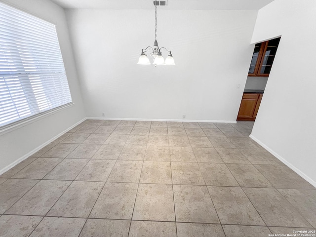 spare room featuring light tile patterned floors, visible vents, baseboards, and a notable chandelier