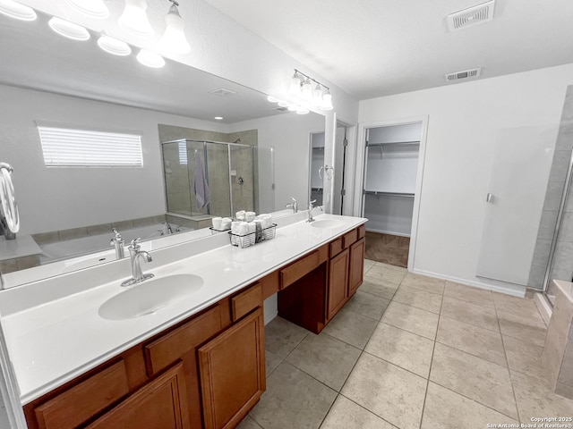 bathroom featuring visible vents, a stall shower, and a sink