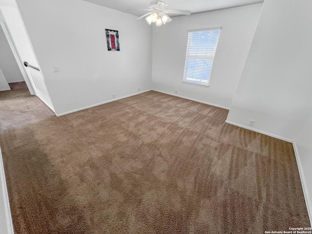 carpeted empty room with a ceiling fan and baseboards