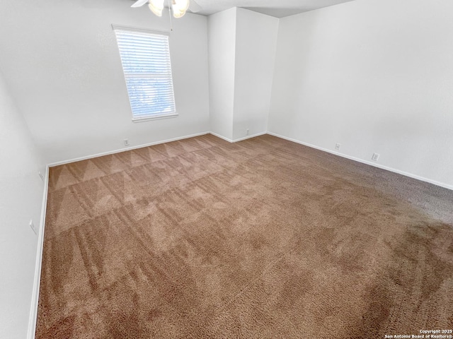 carpeted empty room with baseboards and ceiling fan