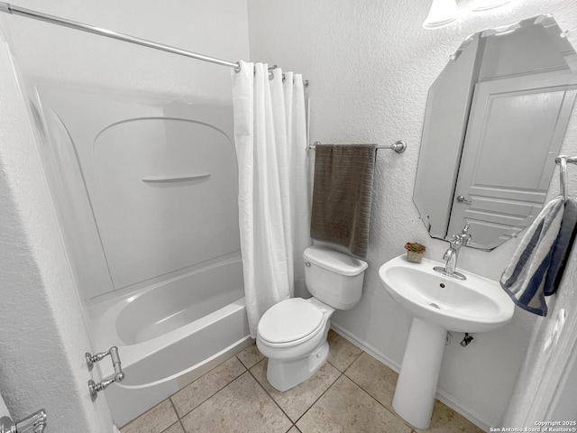 full bathroom featuring tile patterned flooring, baseboards, toilet, shower / tub combo, and a textured wall