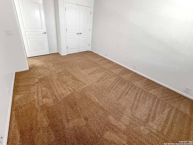 unfurnished bedroom with carpet, a closet, and baseboards