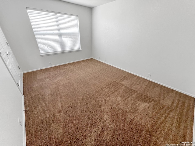 carpeted spare room with baseboards