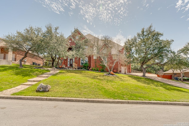 view of front of house featuring brick siding and a front lawn