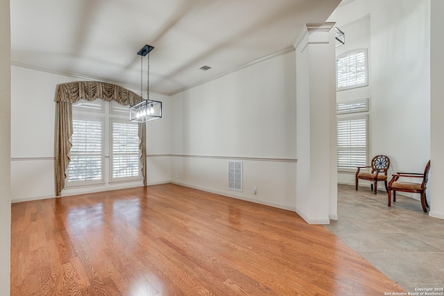 dining space featuring light wood-type flooring, visible vents, crown molding, baseboards, and ornate columns